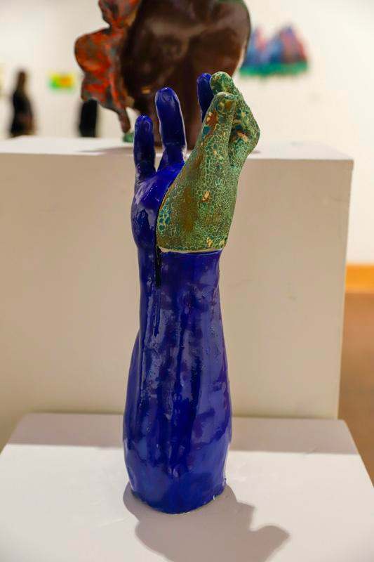 a blue hand sculpture on a white surface