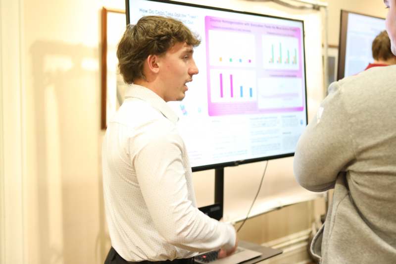 a man standing in front of a large screen