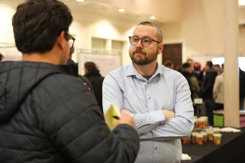 a man standing next to another man