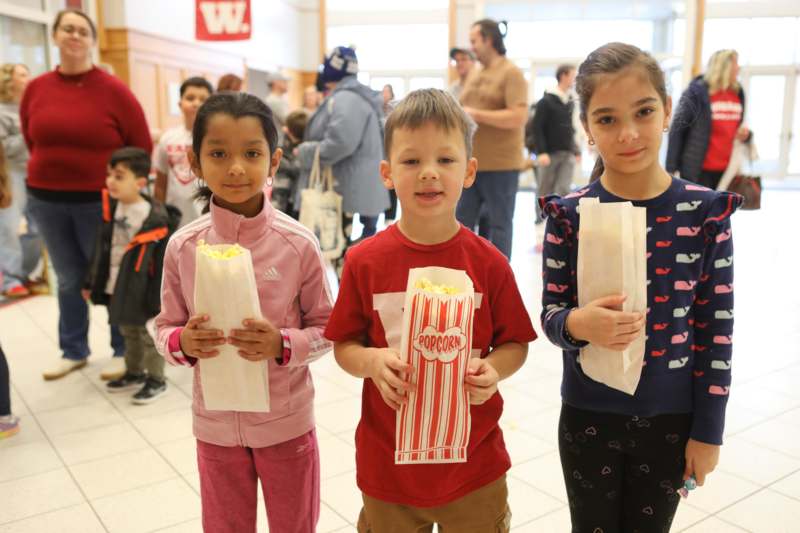 a group of children holding popcorn