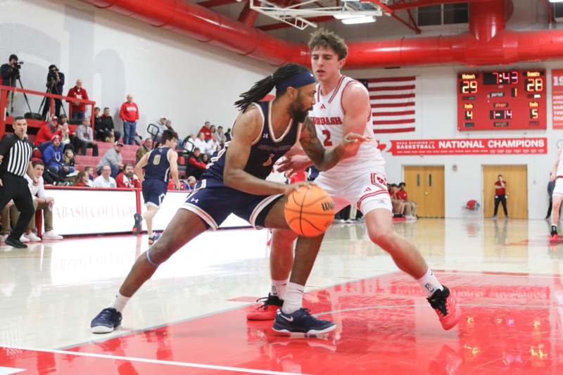 a basketball player in a red uniform dribbling a basketball