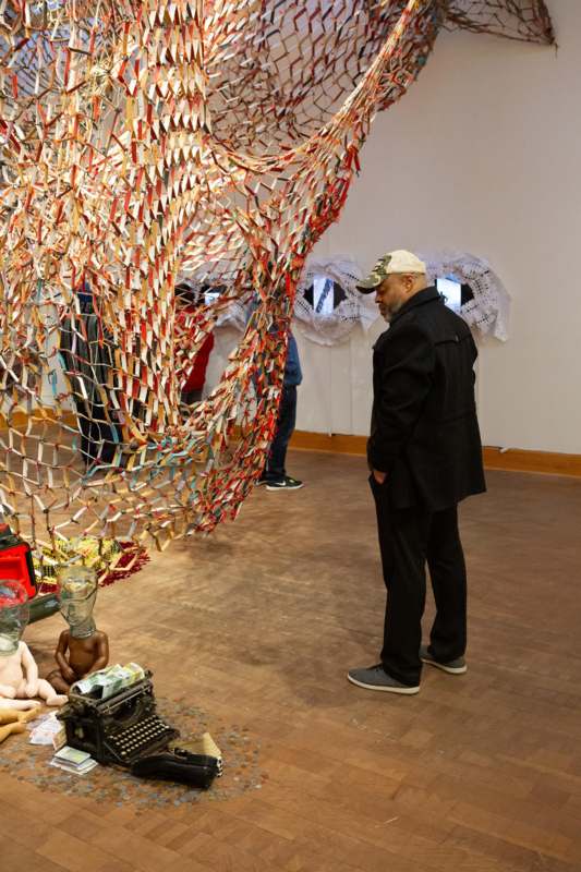 a man standing in front of a large art piece