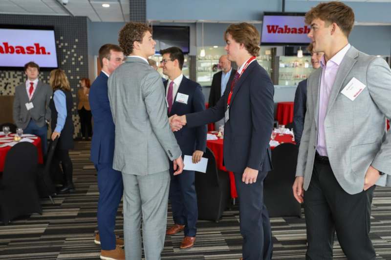 a group of people in suits shaking hands