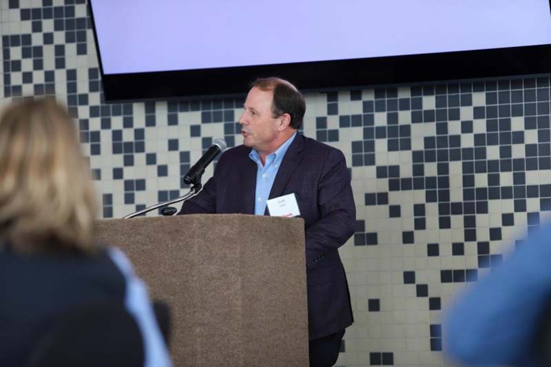 a man standing at a podium speaking into a microphone