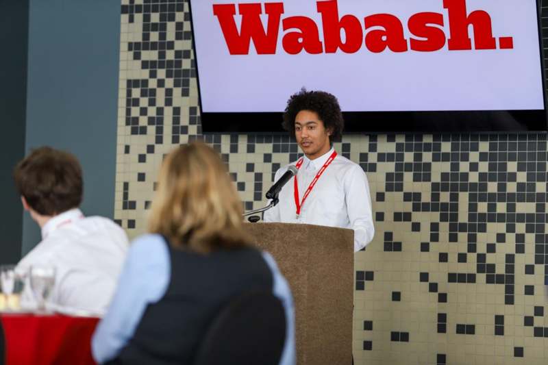 a man standing at a podium with a microphone