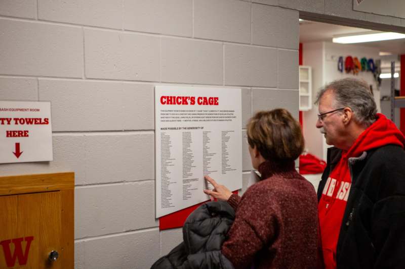 a man and woman looking at a sign on a wall