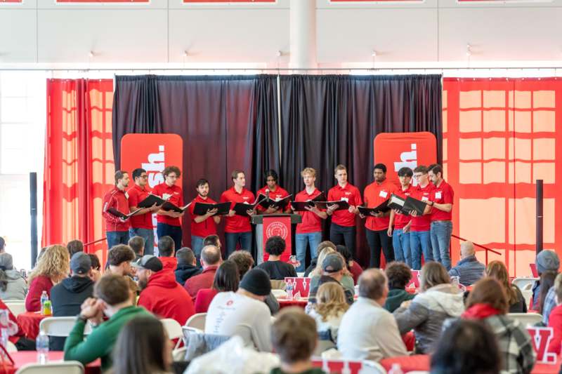 a group of people singing in front of a crowd