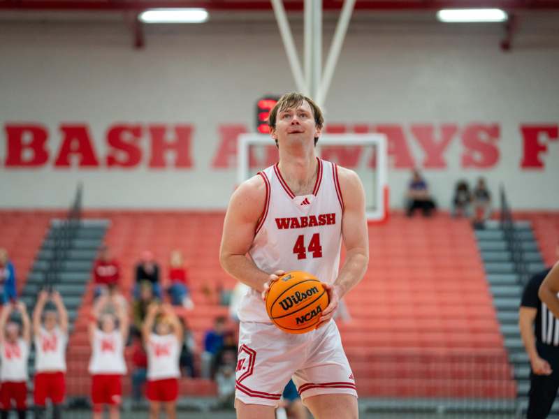 a man in a basketball uniform holding a basketball