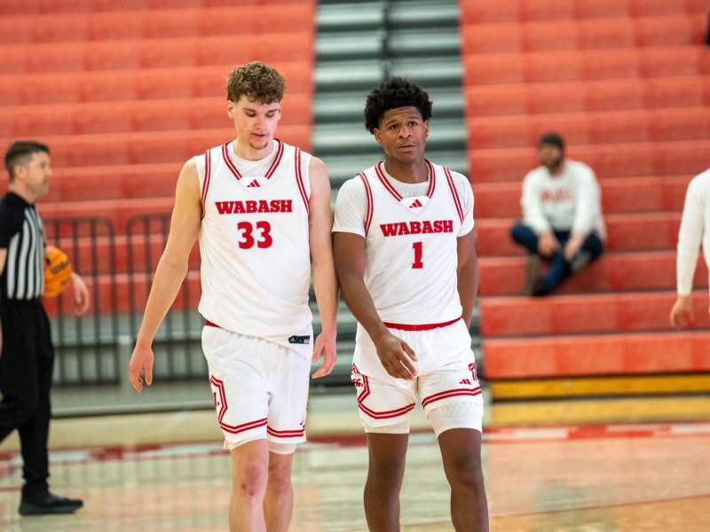 two men in white uniforms on a basketball court