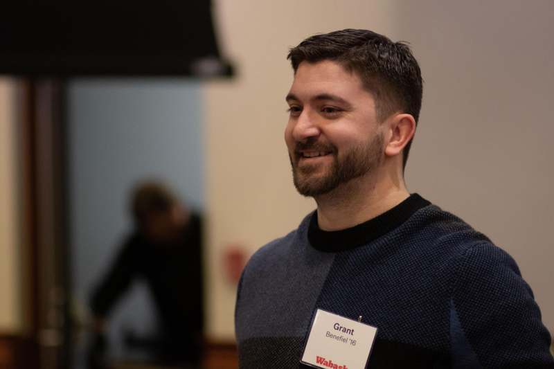 a man smiling with a name tag