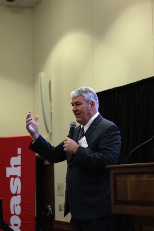 a man in a suit holding a microphone