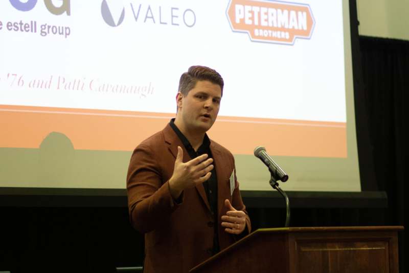 a man standing at a podium giving a presentation