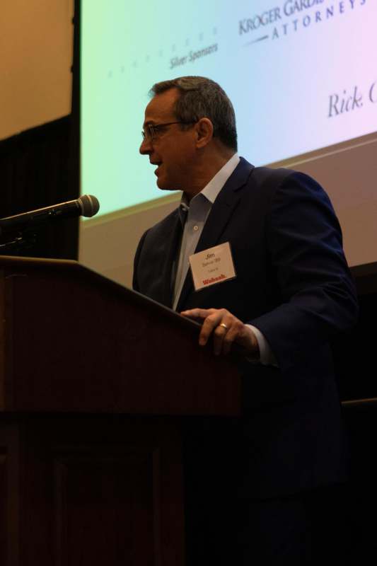 a man standing at a podium speaking into a microphone