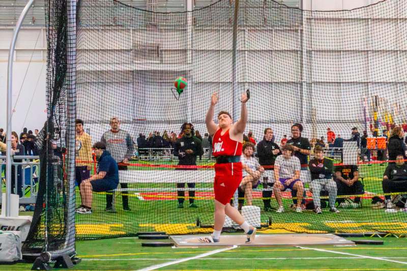 a man throwing a ball in a competition
