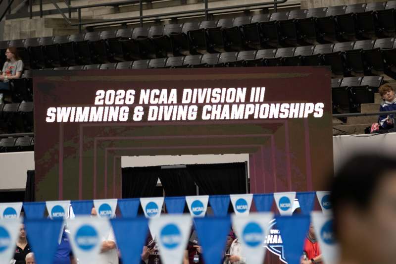 a large screen with white text and blue and white flags