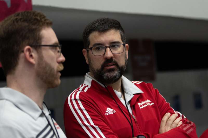 a man in a red jacket with his arms crossed