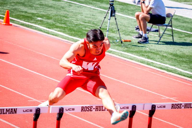 a man jumping over a hurdle