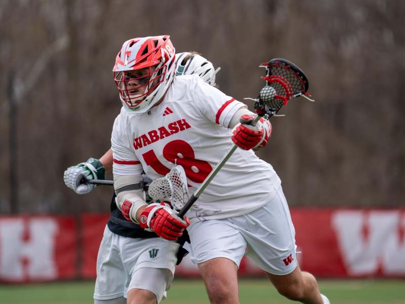 a group of people wearing helmets and holding lacrosse sticks