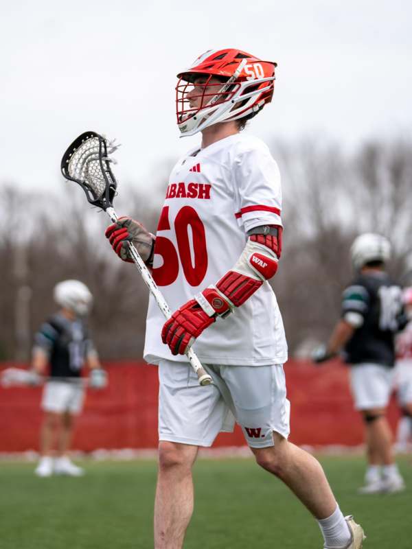 a man wearing a helmet and holding a lacrosse stick