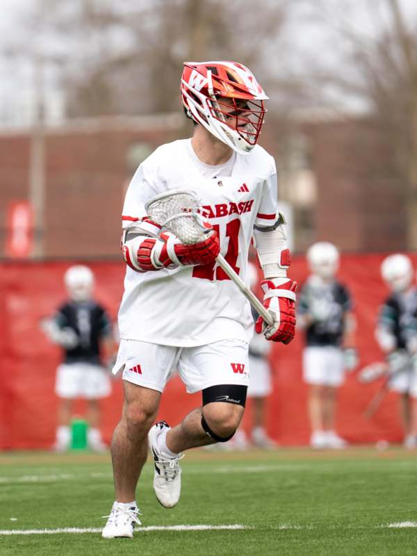 a man wearing a lacrosse uniform and holding a stick