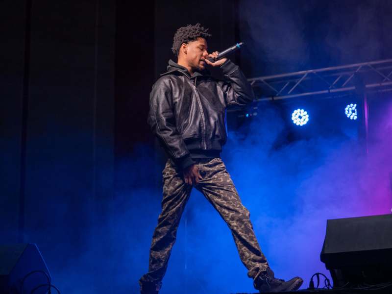 a man singing into a microphone on a stage