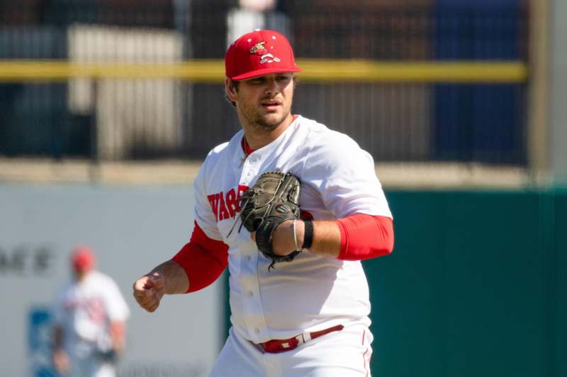 a baseball player in a red hat and white uniform
