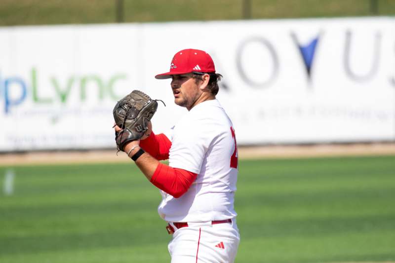 a baseball player in a red hat and white uniform