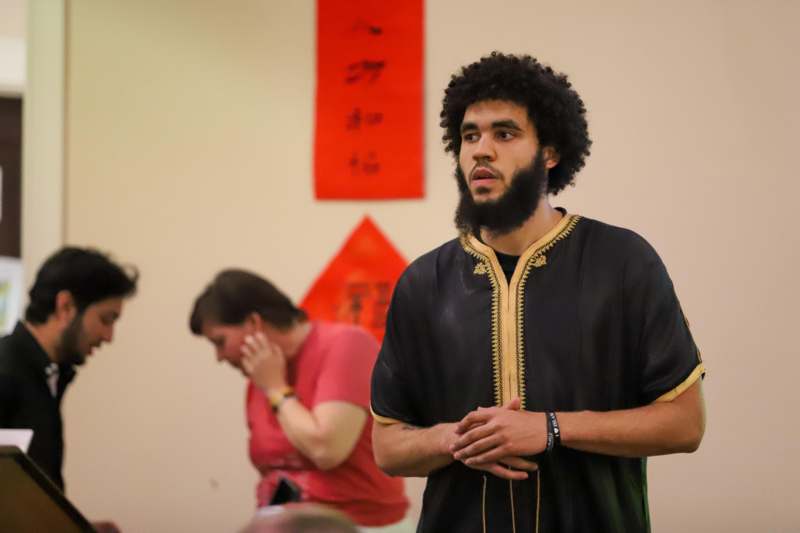 a man with a beard standing in front of a woman