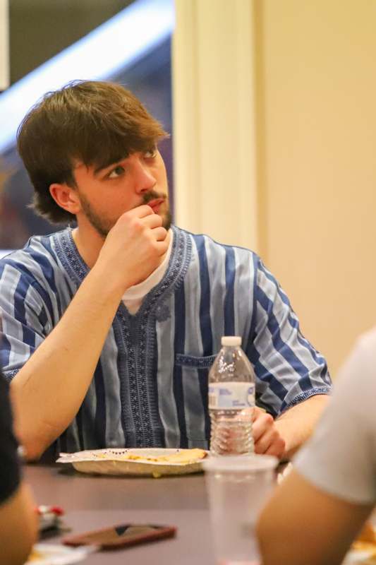 a man sitting at a table with a bottle of water and food
