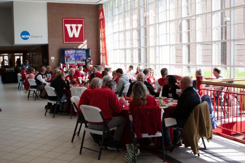 a group of people sitting at tables in a room with large windows