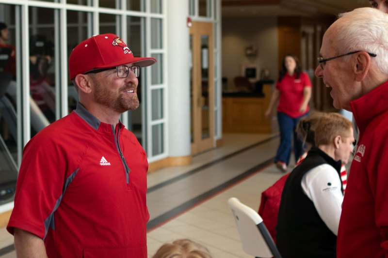 a man in a red cap and red jacket talking to a woman