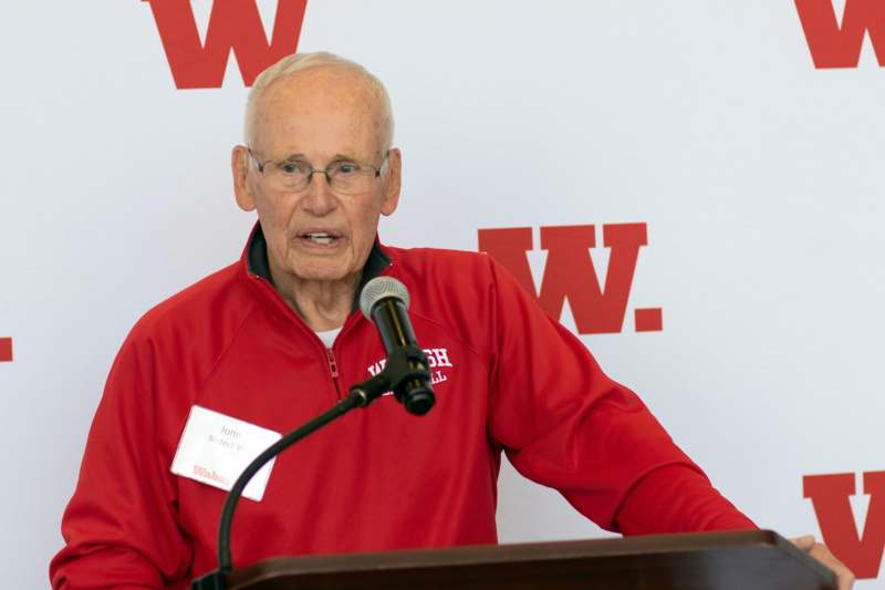 an old man speaking into a microphone