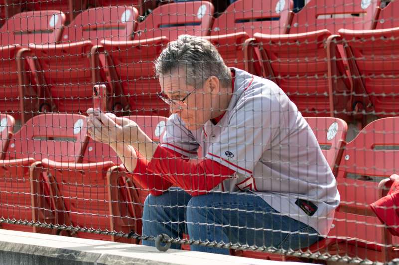 a man sitting on a bench looking at a cell phone
