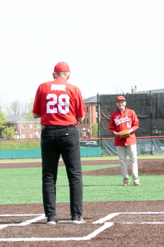 a man in red shirt and baseball glove standing on a field