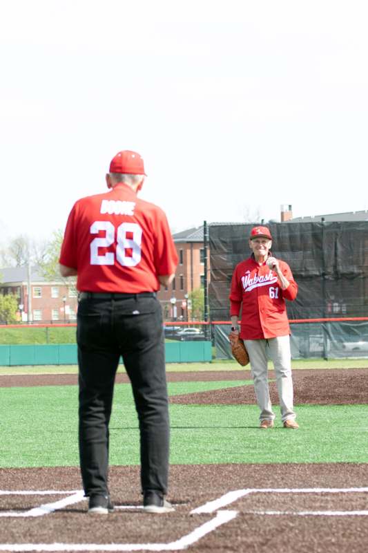 a man in red uniform standing on a field with a baseball glove