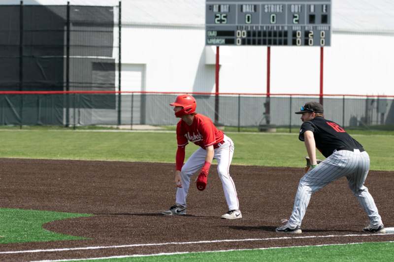 a baseball player in red and white uniform on a field