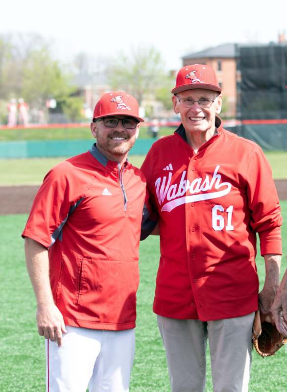 two men wearing red shirts and hats