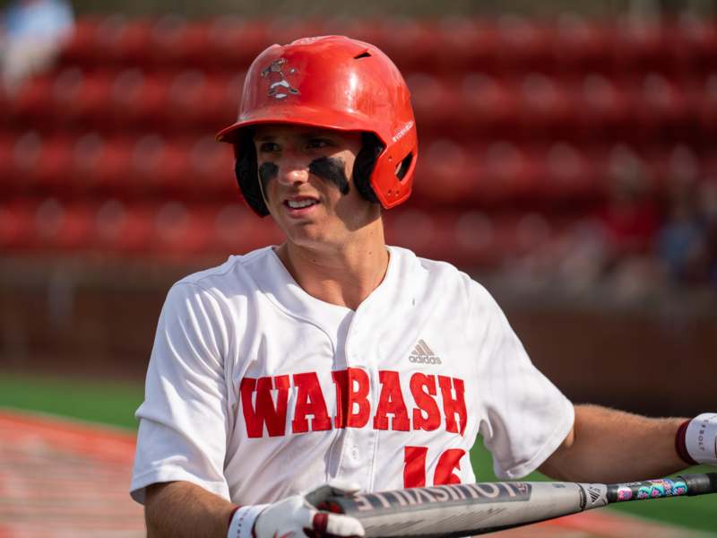 a man wearing a helmet and holding a baseball bat