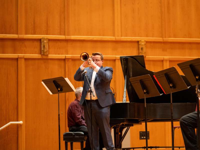 a man playing a trumpet on a stage