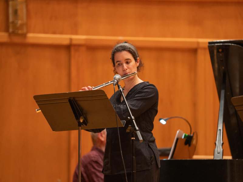 a woman playing flute on a stand