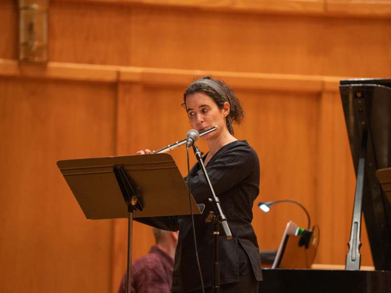 a woman playing a flute on a stand