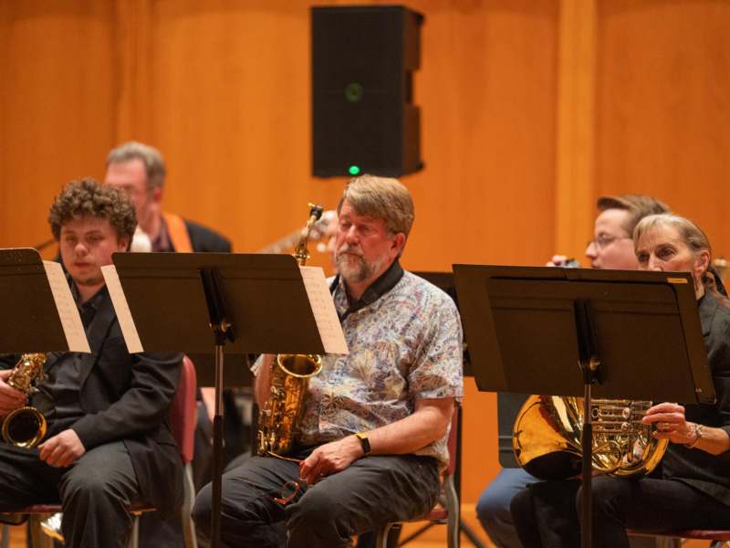 a group of people sitting in chairs playing instruments