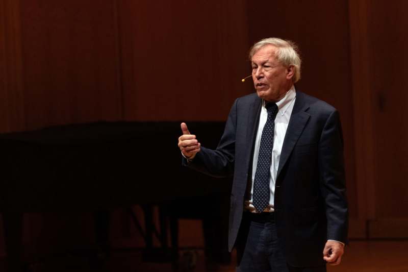 a man in a suit and tie holding his thumb up