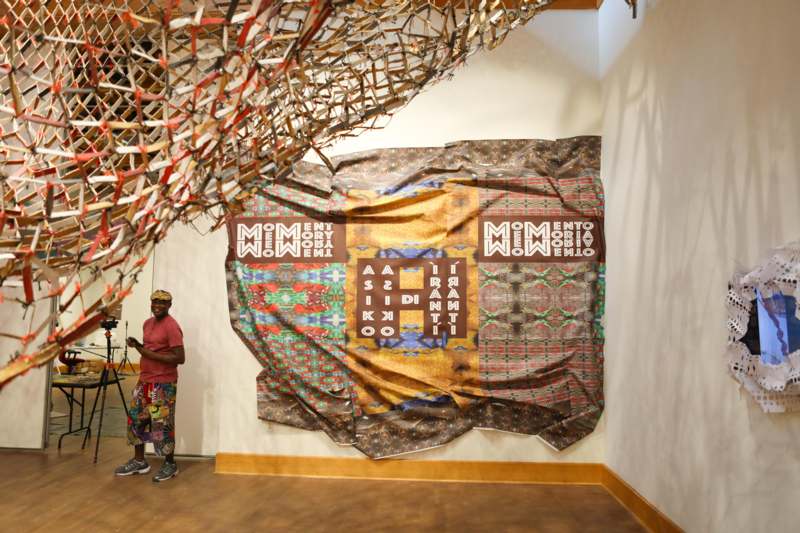 a man standing in front of a large piece of art