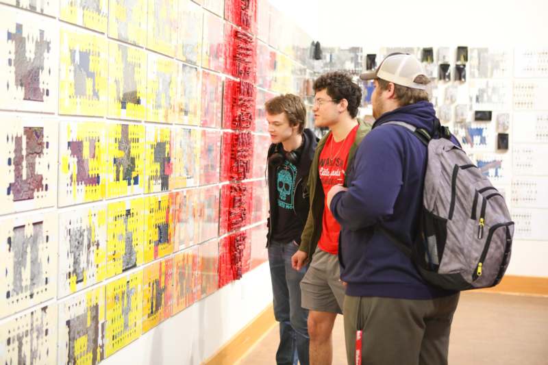 a group of people looking at a wall with many pieces of paper