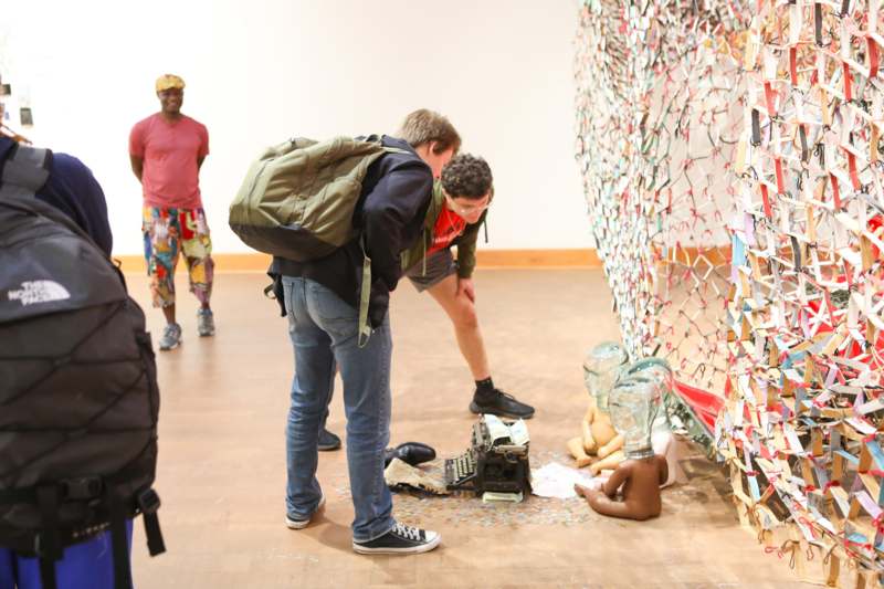 a group of people standing in a room with a broken mannequin