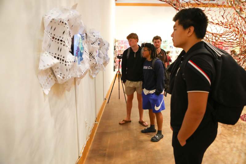 a group of people looking at art on a wall