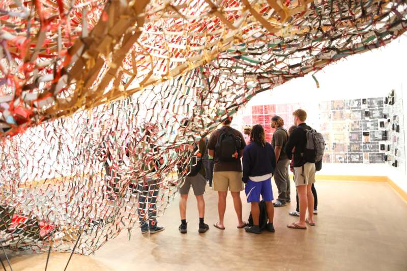 a group of people standing in a room with a colorful wall