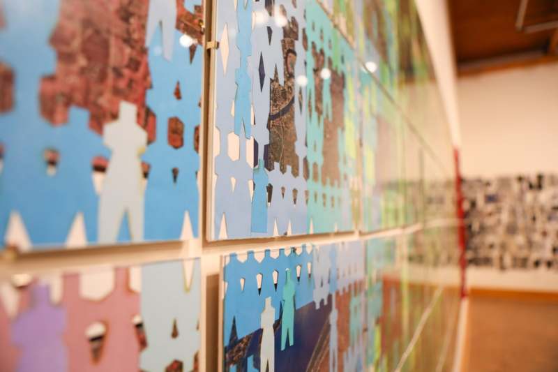 a wall with pieces of paper cut out of people