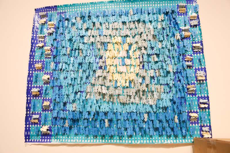 a blue and white piece of paper with clothespins on it